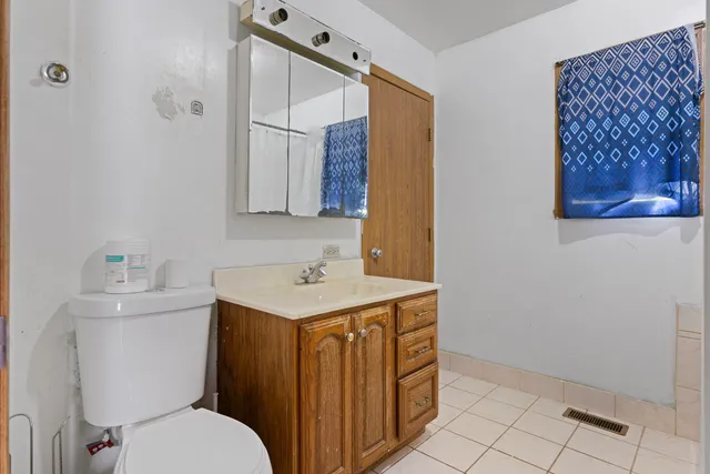 a bathroom with a toilet a sink and mirror