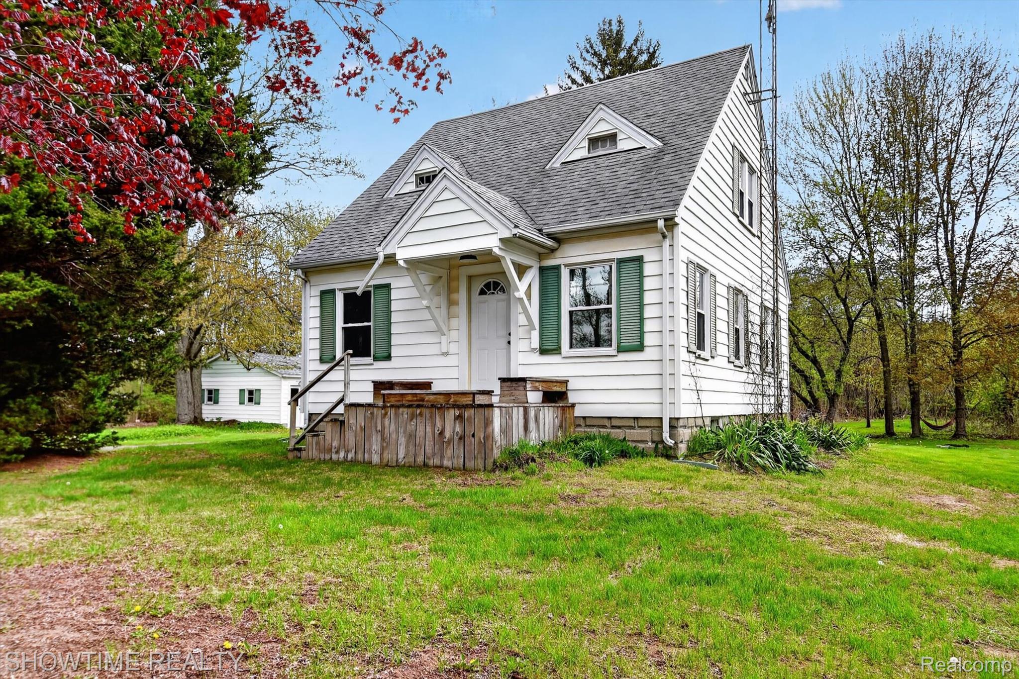 2970 Range Road Port Huron, MI 48060 - Photo 27 of 31 White clapboard exterior with green shutters, a front porch, and a gray shingle roof