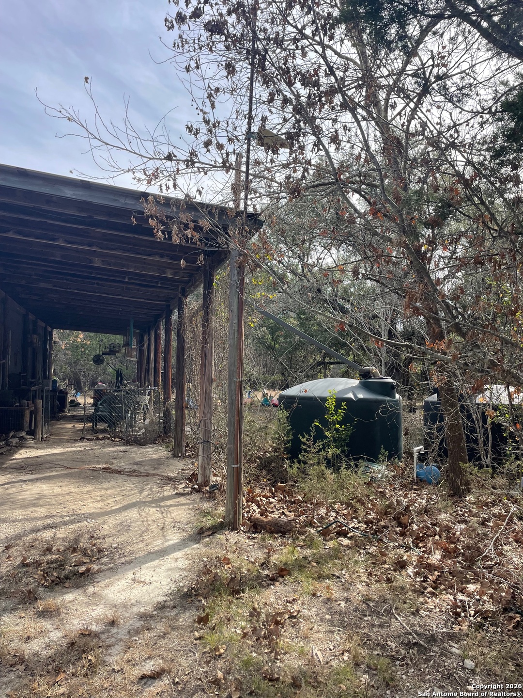 7321 Highway 173 Bandera, TX 78003 - Photo 13 of 28 a backyard of a house with table and chairs under an umbrella