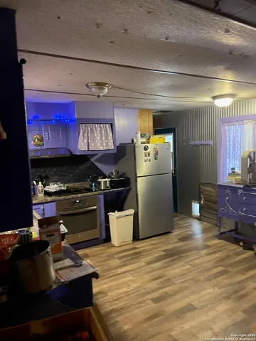 a kitchen with stainless steel appliances granite countertop a refrigerator a stove and a sink