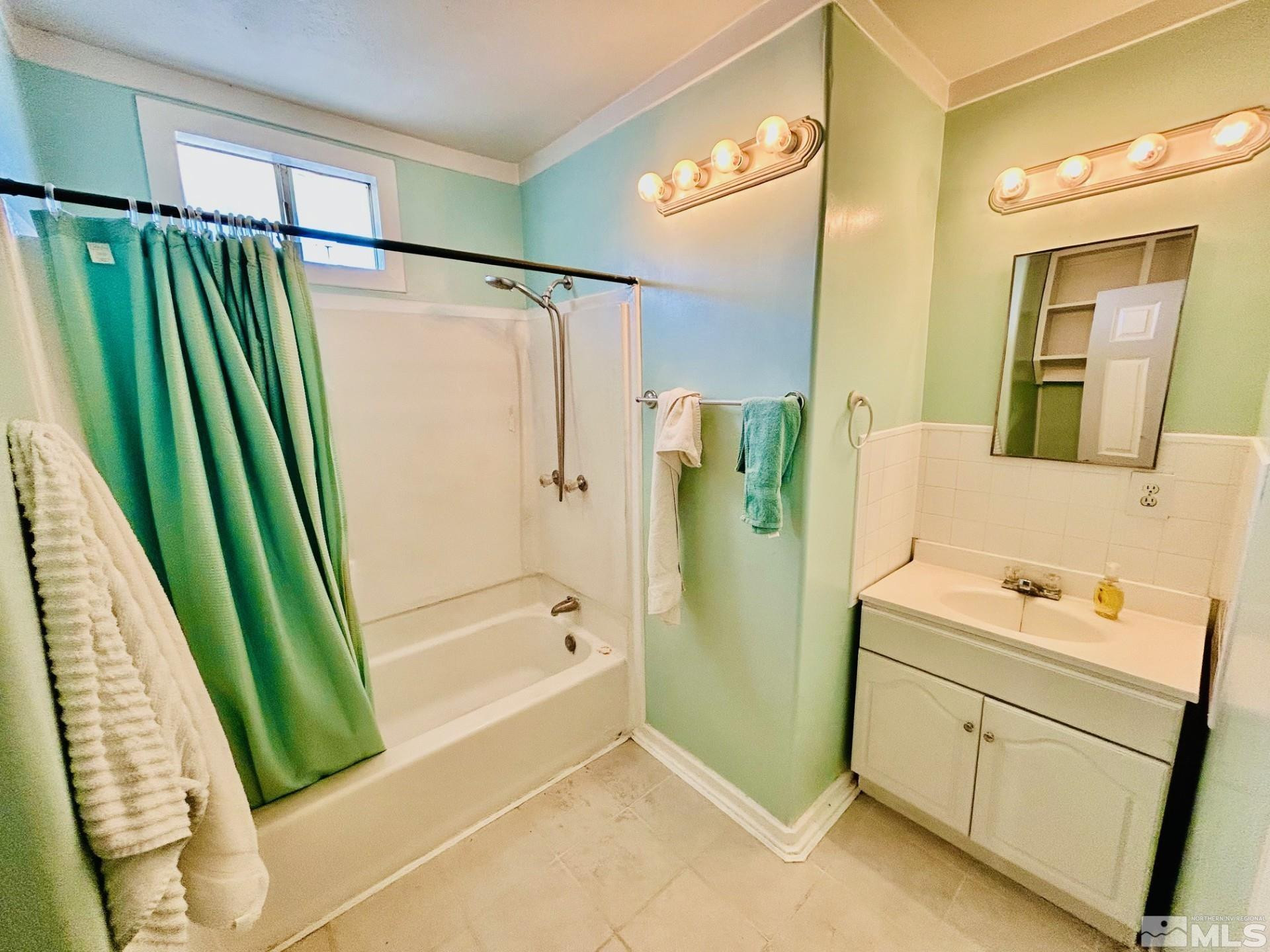 524 E Avenue Gabbs, NV 89409 - Photo 11 of 15 a bathroom with a green shower a sink and a mirror