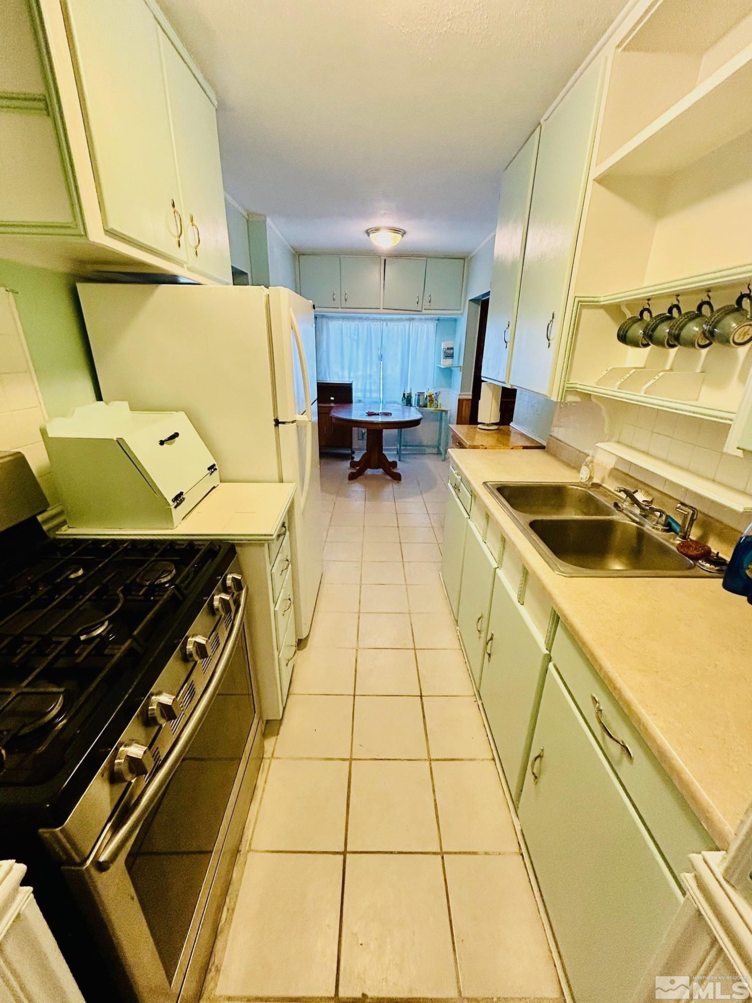 524 E Avenue Gabbs, NV 89409 - Photo 7 of 15 a kitchen with a sink and wooden cabinets