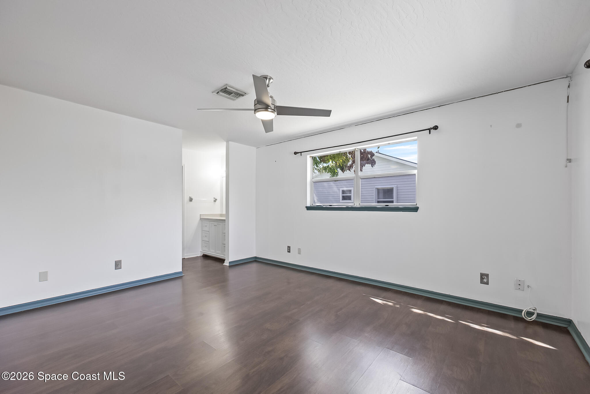 854 Dale Circle Sebastian, FL 32958 - Photo 12 of 31 an empty room with wooden floor and ceiling fan