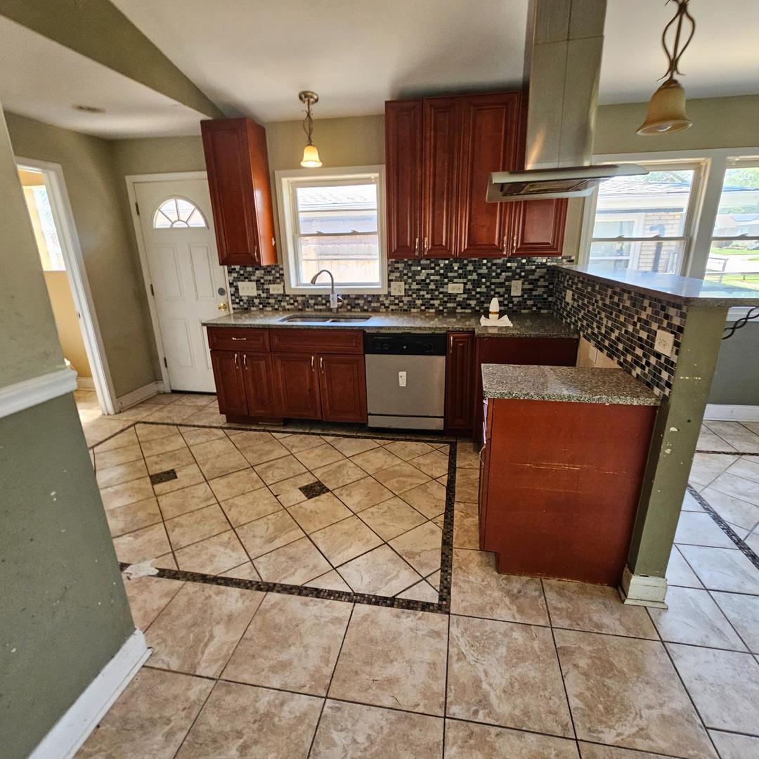 14237 Minerva Avenue Dolton, IL 60419 - Photo 5 of 17 a kitchen with stainless steel appliances granite countertop a stove a sink and a microwave