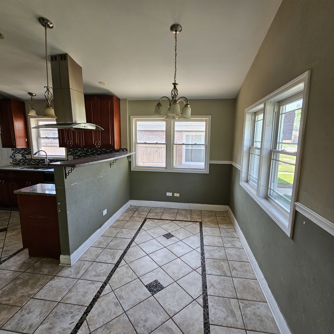 14237 Minerva Avenue Dolton, IL 60419 - Photo 6 of 17 a kitchen with granite countertop a stove a sink and a refrigerator