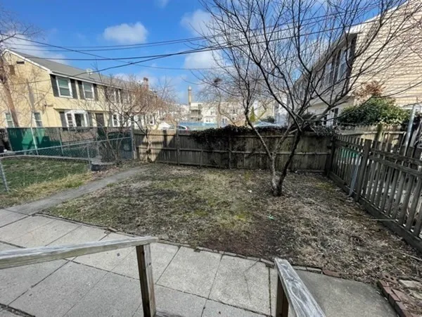 a view of a yard with wooden fence