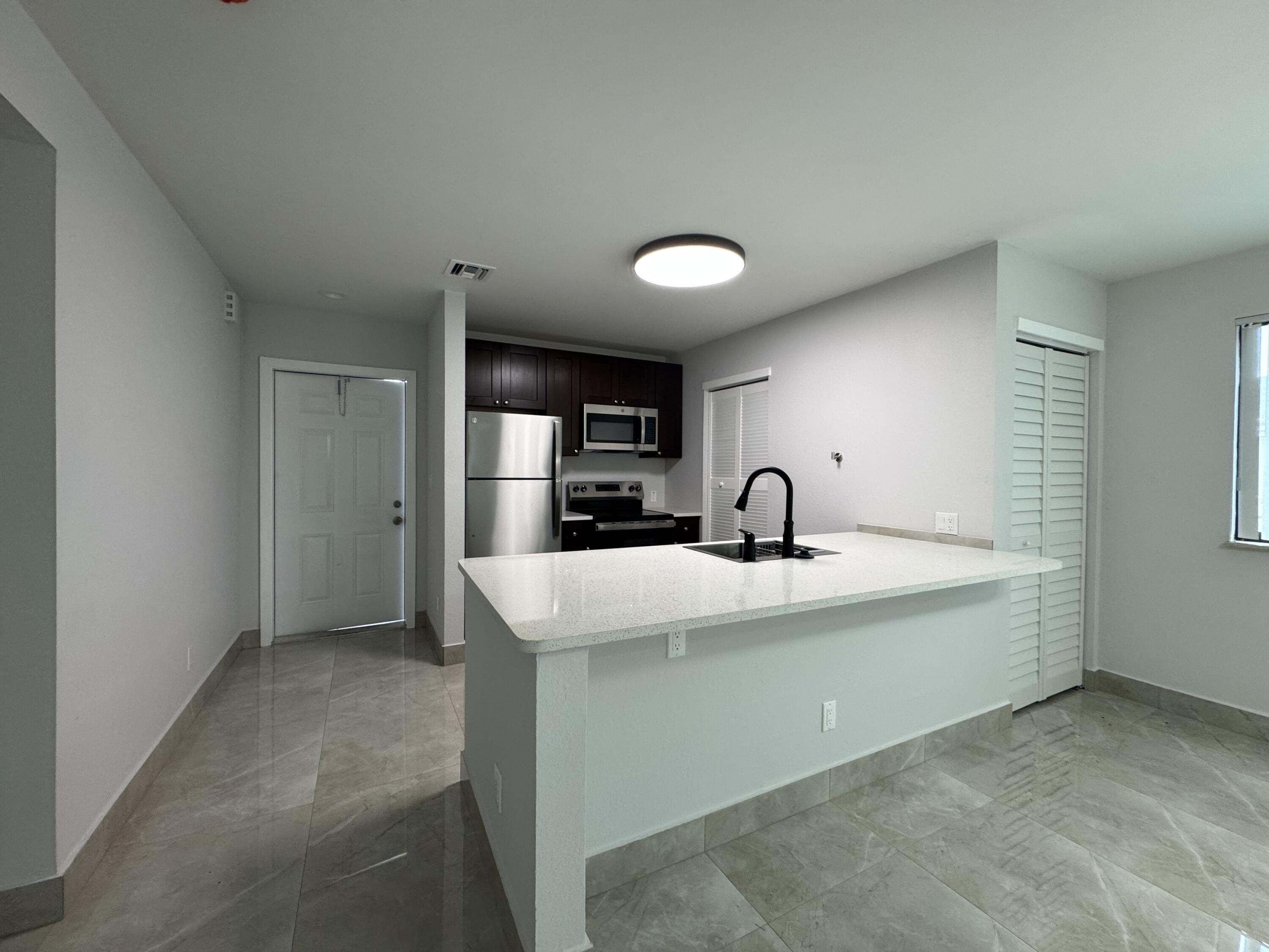 400 Northeast 30th Street, Unit 2 Pompano Beach, FL 33064 - Photo 18 of 22 a view of a kitchen with a sink and a refrigerator