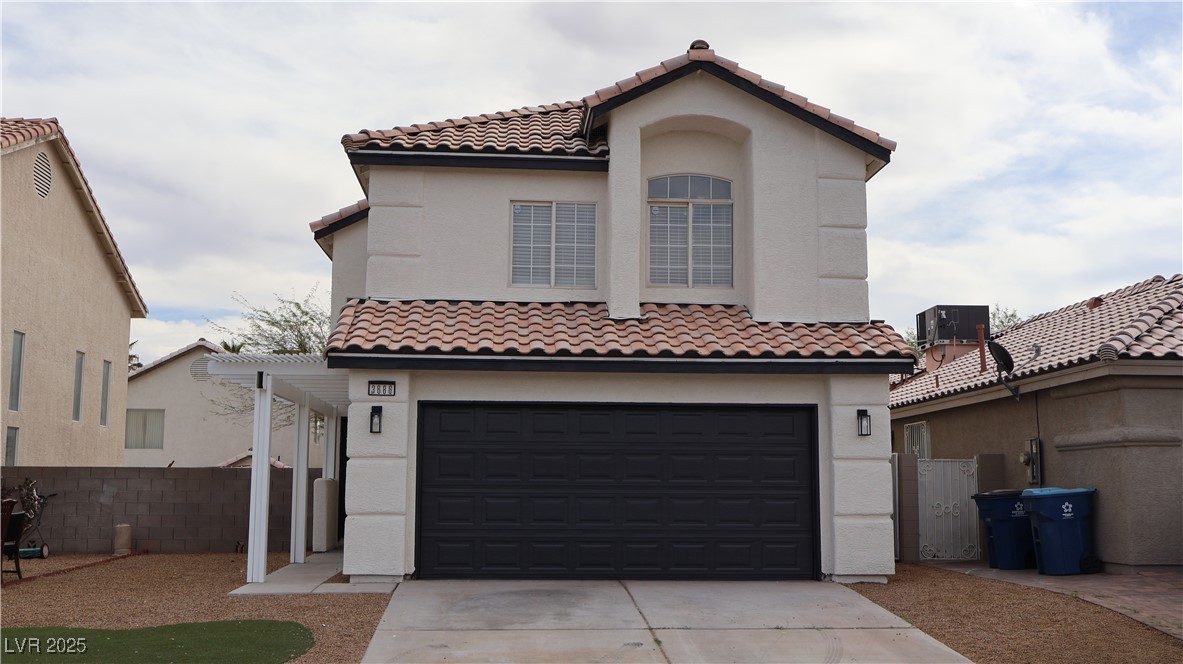 Mediterranean / spanish home with an attached garage, driveway, fence, and a tile roof