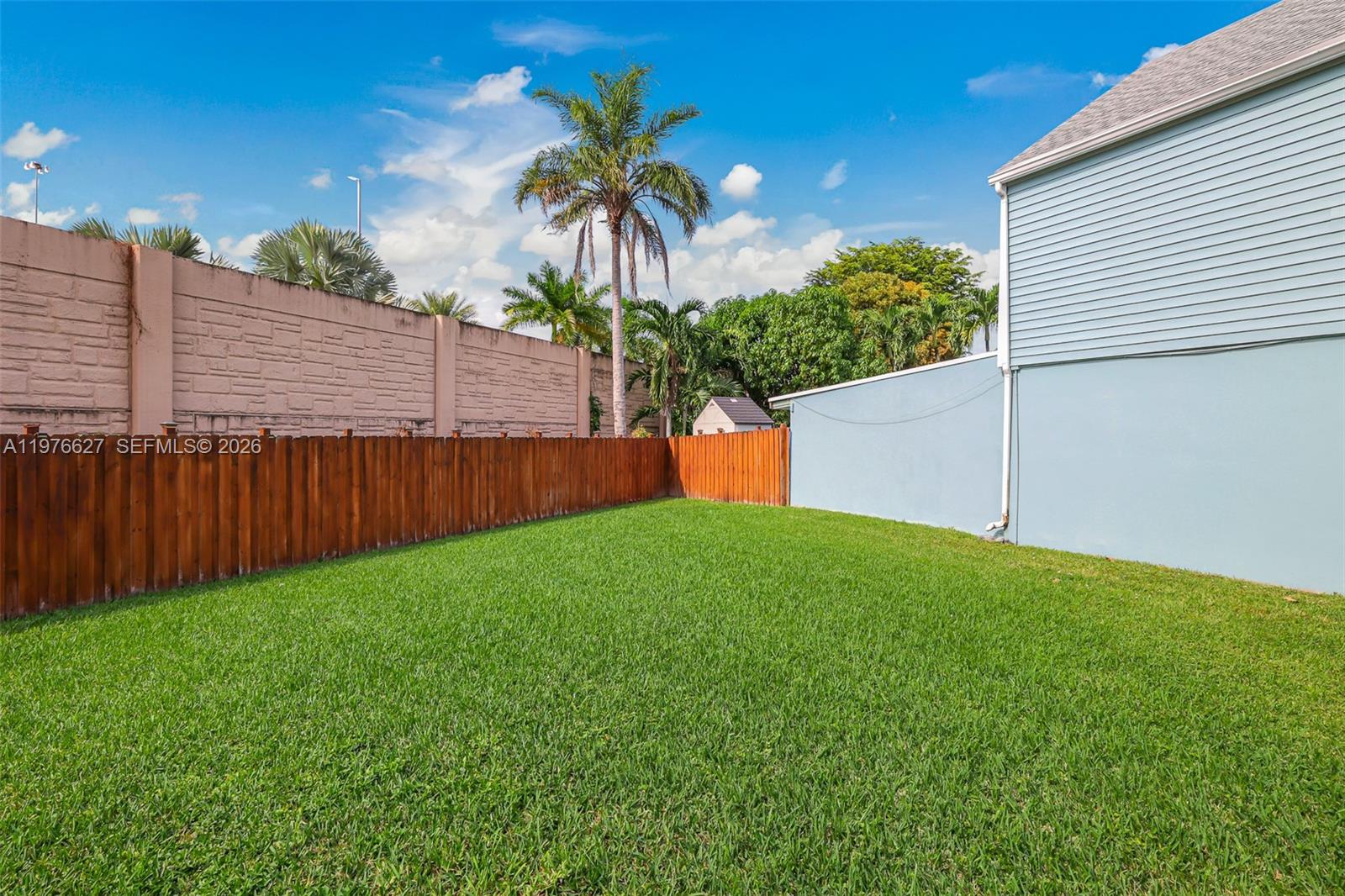 11747 Southwest 113th Terrace Miami, FL 33186 - Photo 32 of 46 a backyard of a house with plants and wooden fence