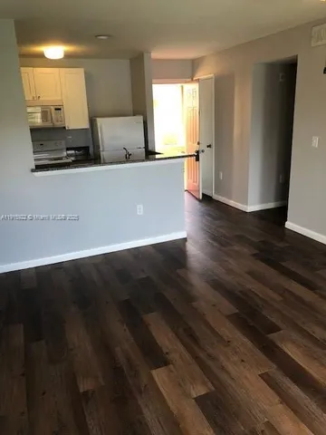 a view of a kitchen with wooden floor and a sink