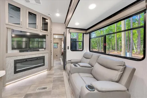 a living room with furniture a flat screen tv and a fireplace