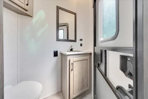 a bathroom with a mirror sink and toilet