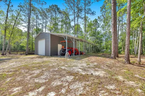 a view of a backyard with large trees and wooden fence