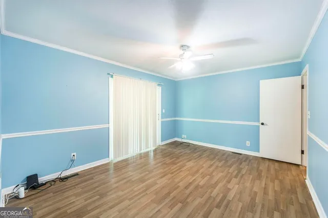 a view of an empty room with wooden floor