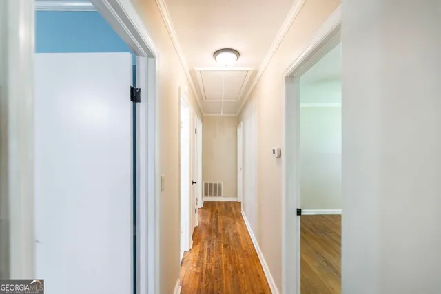 a view of a hallway with wooden floor and entryway