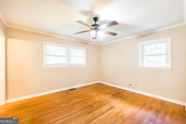 a view of a room with wooden floor and a ceiling fan