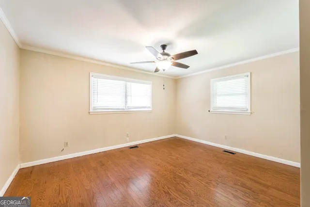 a view of a room with wooden floor and a ceiling fan