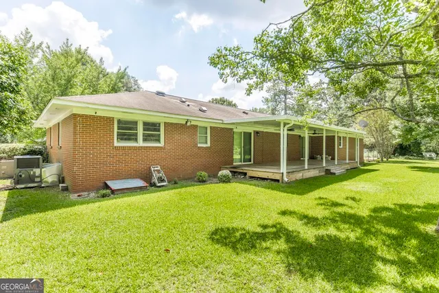 a view of a house with a yard and sitting area