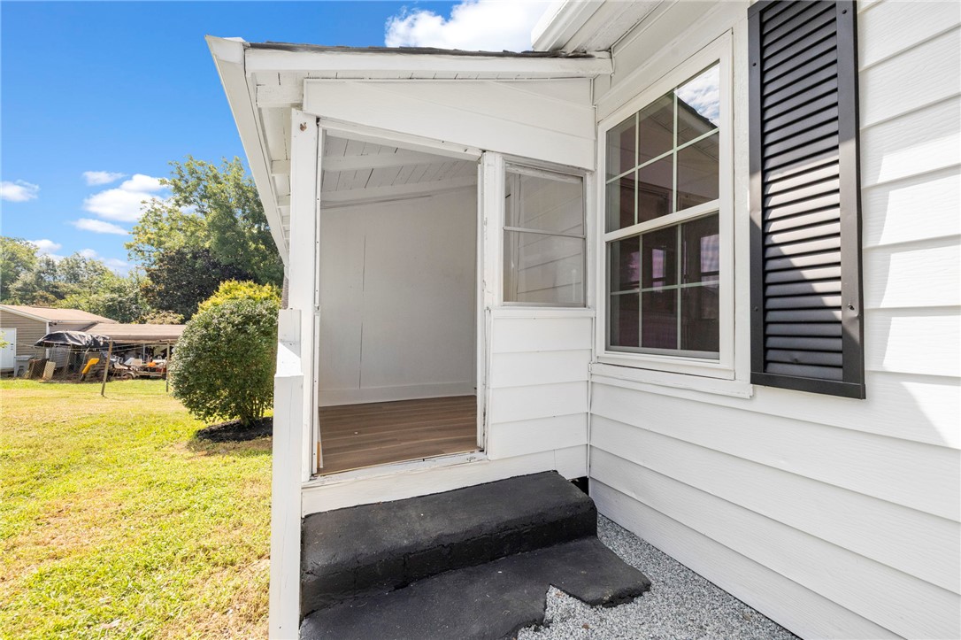 201 South 8th Street Easley, SC 29640 - Photo 24 of 28 An inviting side entrance leads into a bright sunroom with classic siding and shutters.