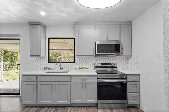 a kitchen with stainless steel appliances a stove a sink and a microwave