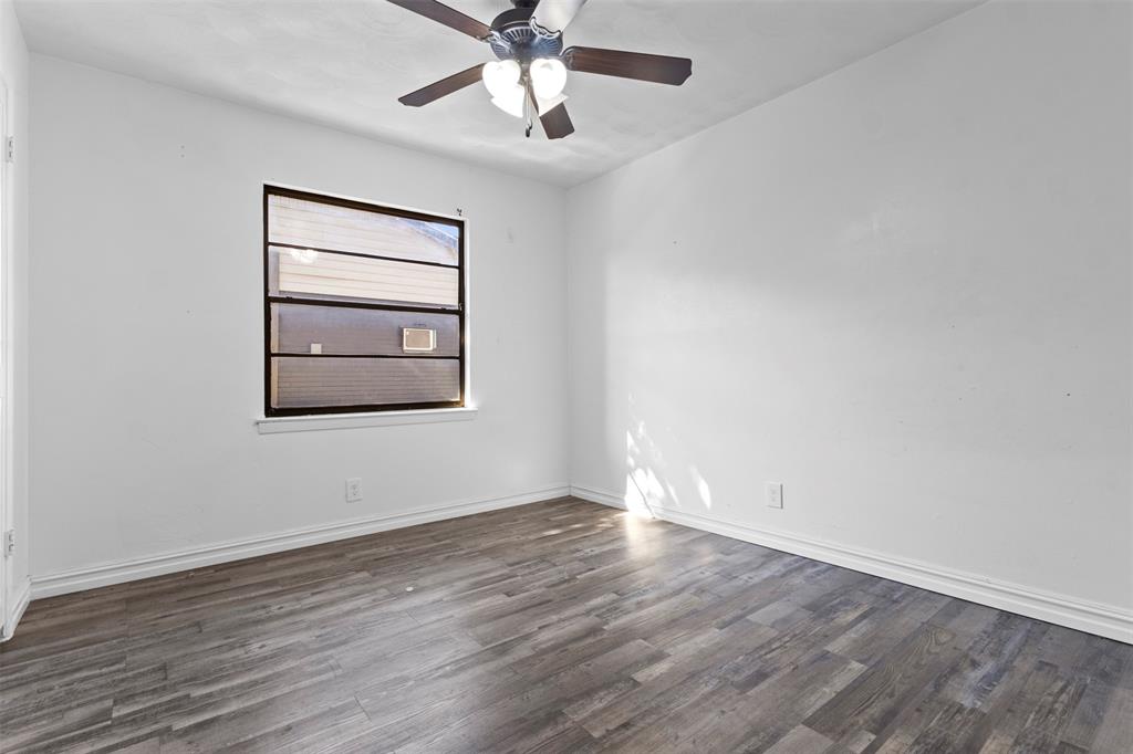 1809 Balla Way Grand Prairie, TX 75051 - Photo 21 of 26 an empty room with wooden floor chandelier fan and windows