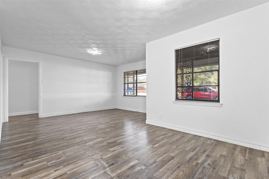 1809 Balla Way Grand Prairie, TX 75051 - Photo 5 of 26 an empty room with wooden floor and windows