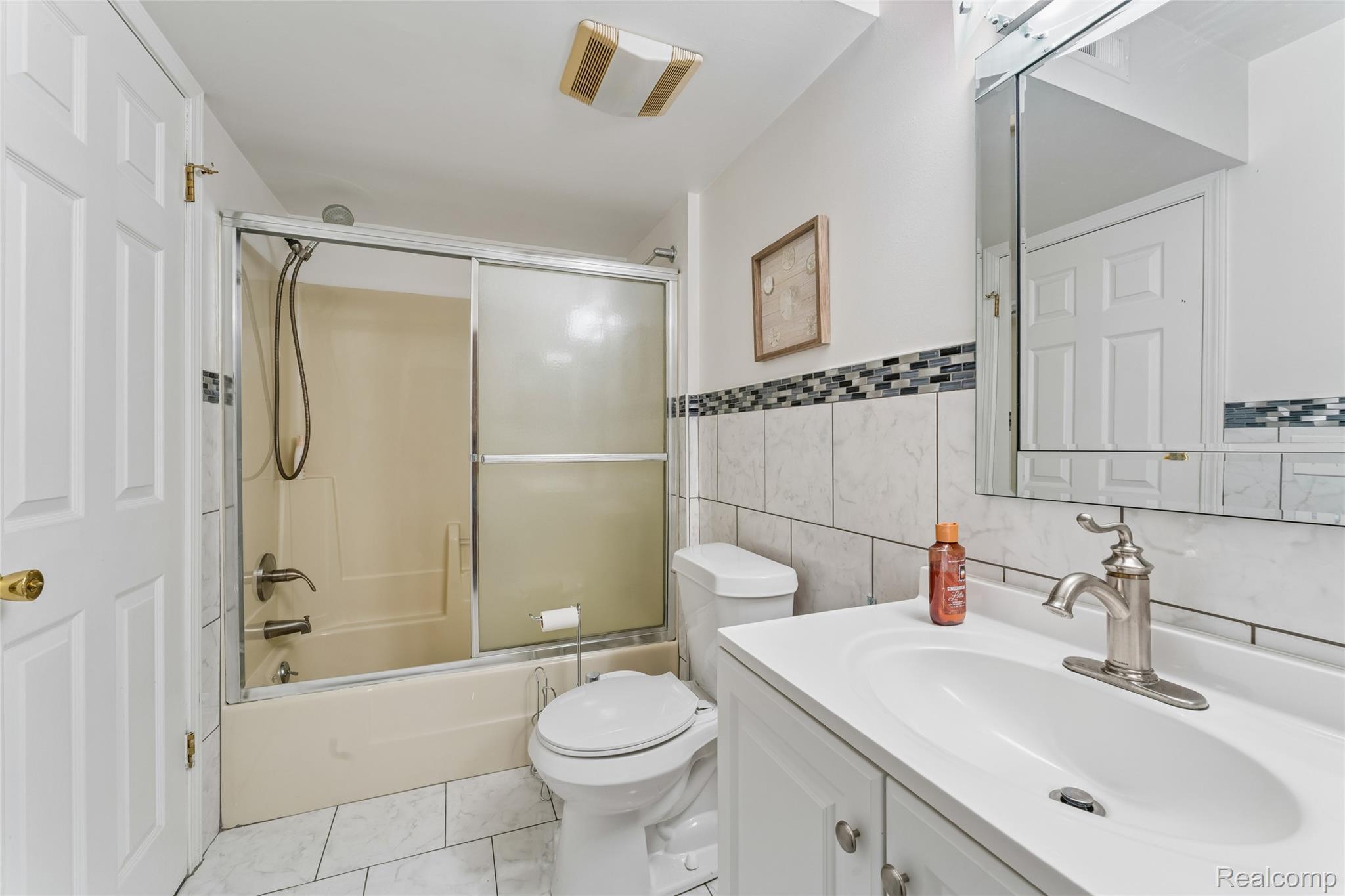 704 South Brady Road, Unit B Dearborn, MI 48124 - Photo 14 of 16 White vanity with integrated sink, brushed nickel faucet, and a wall-mounted medicine cabinet