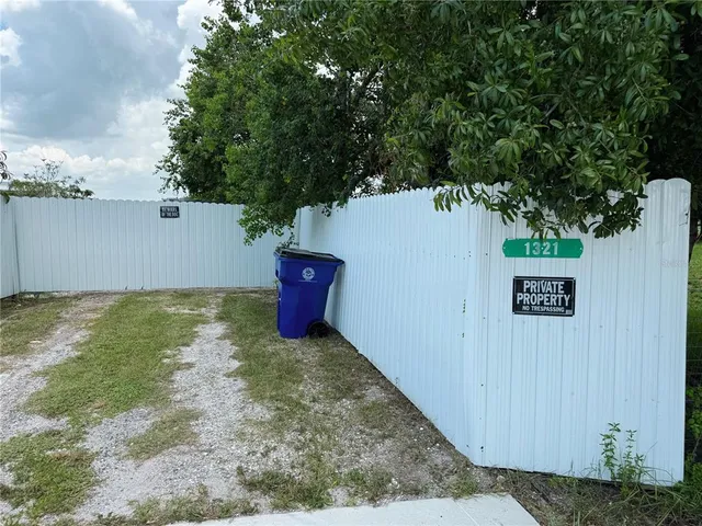 a view of a yard with an tree and wooden fence