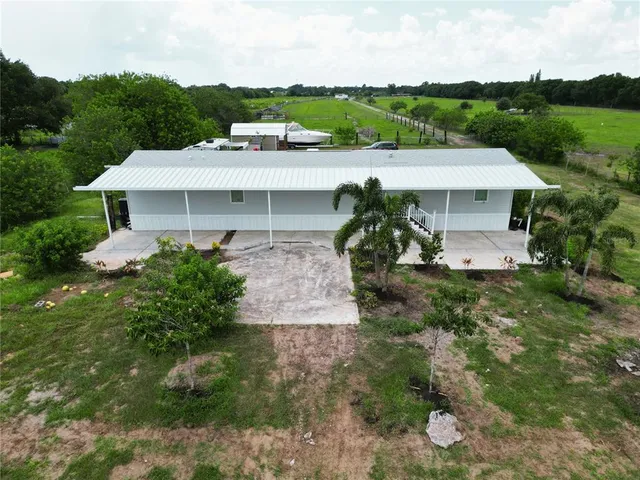 a front view of a house with a yard and potted plants