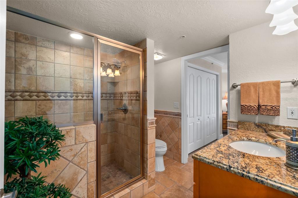 2937 South Atlantic Avenue, Unit 1907 Daytona Beach Shores, FL 32118 - Photo 25 of 55 a bathroom with a granite countertop shower a sink and a mirror
