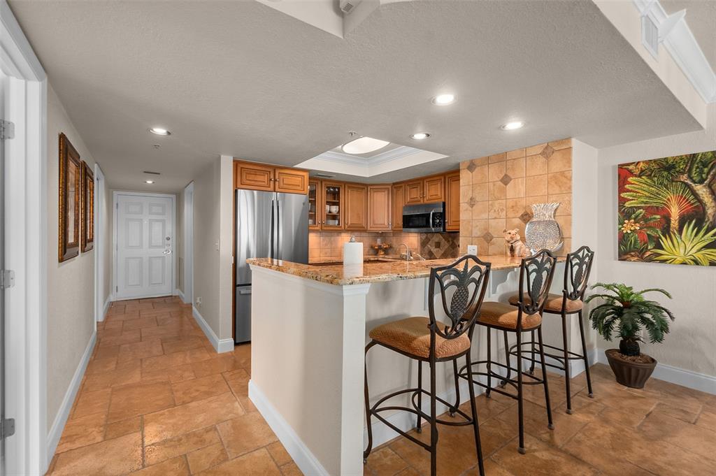 2937 South Atlantic Avenue, Unit 1907 Daytona Beach Shores, FL 32118 - Photo 9 of 55 a kitchen with stainless steel appliances kitchen island granite countertop a refrigerator and microwave