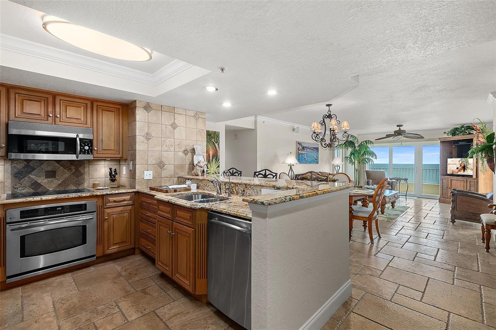 2937 South Atlantic Avenue, Unit 1907 Daytona Beach Shores, FL 32118 - Photo 10 of 55 a kitchen with a sink and chairs