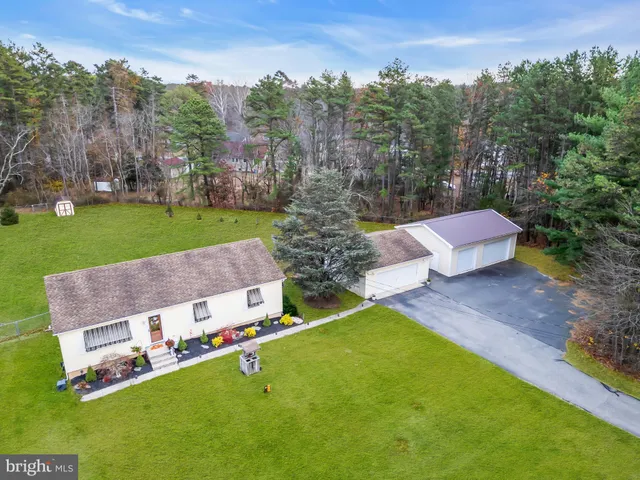 an aerial view of a house with swimming pool garden and trees
