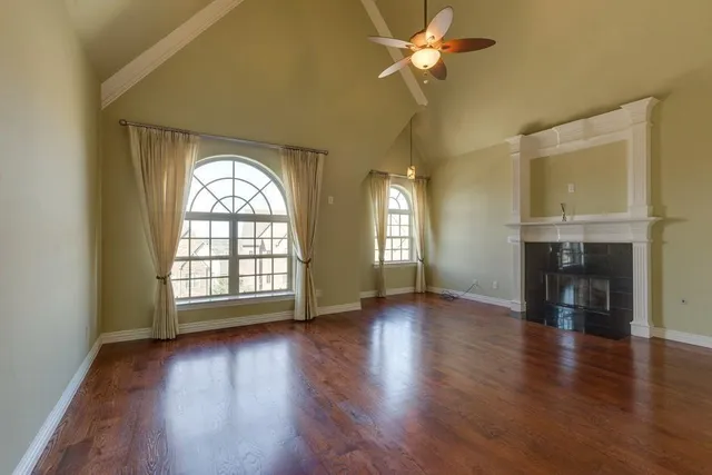 a view of a livingroom with a fireplace wooden floor and window