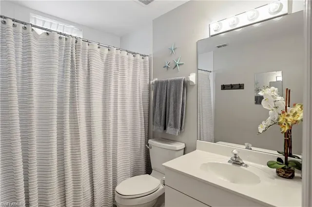 a bathroom with a sink a toilet and shower curtain