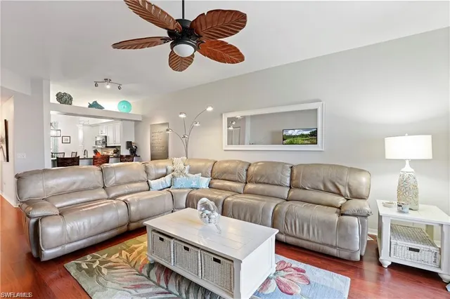 a living room with furniture kitchen view and a chandelier