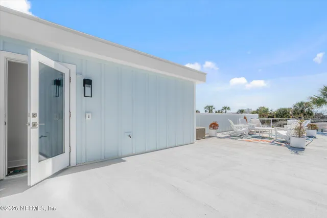 a view of a patio with table and chairs potted plants and palm tree
