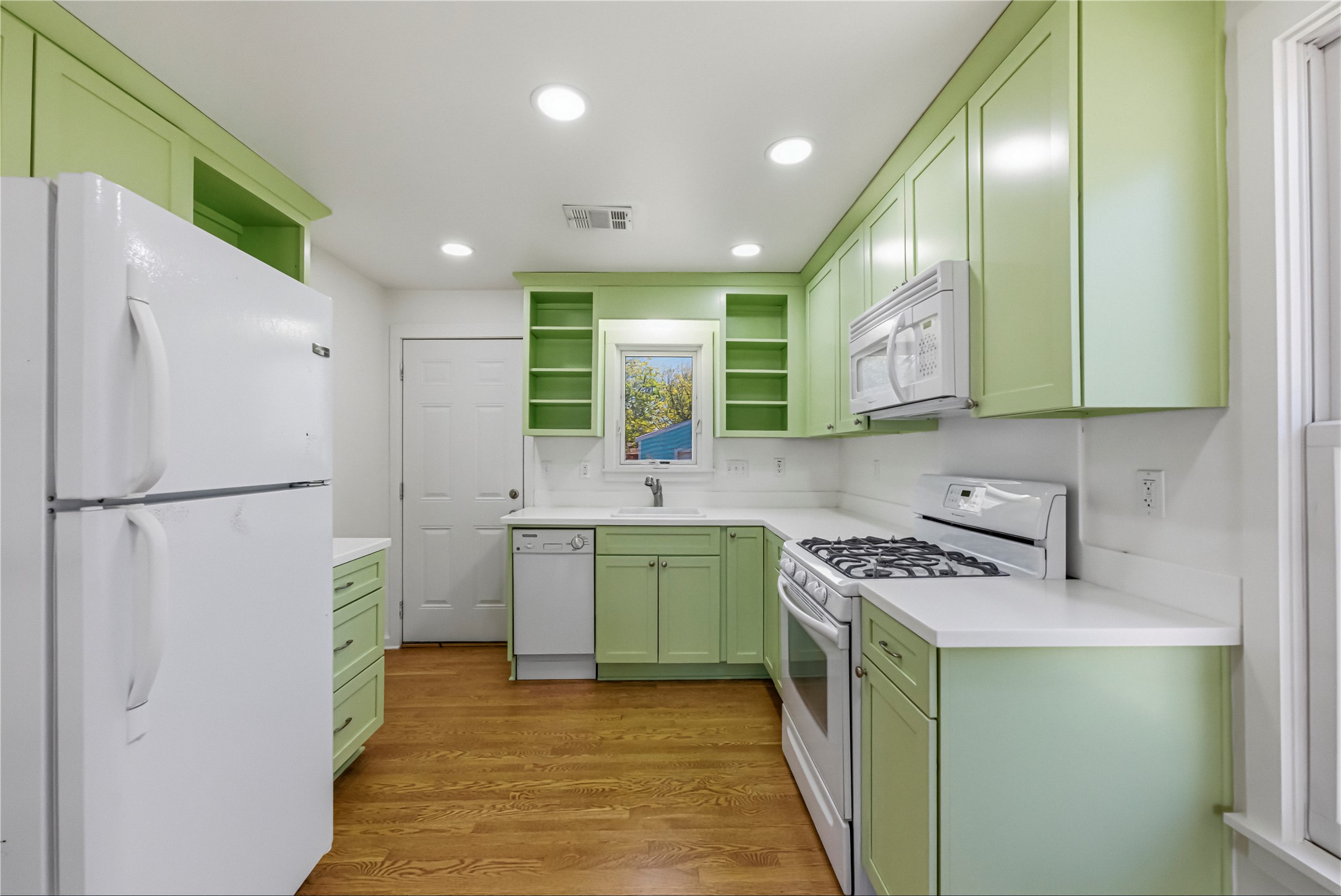 503 West Croslin Street Austin, TX 78752 - Photo 7 of 24 a kitchen with a refrigerator a sink and wooden cabinets