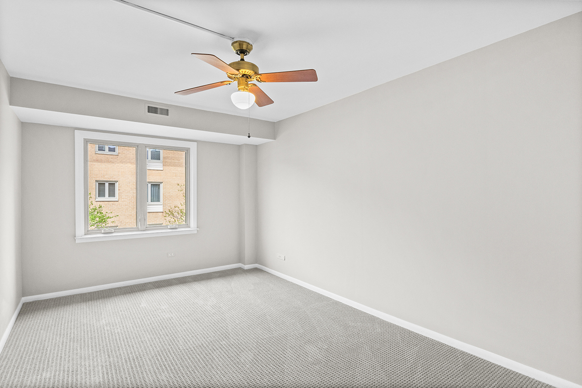 2420 West Talcott Road, Unit 211 Park Ridge, IL 60068 - Photo 19 of 28 an empty room with a window and a fan