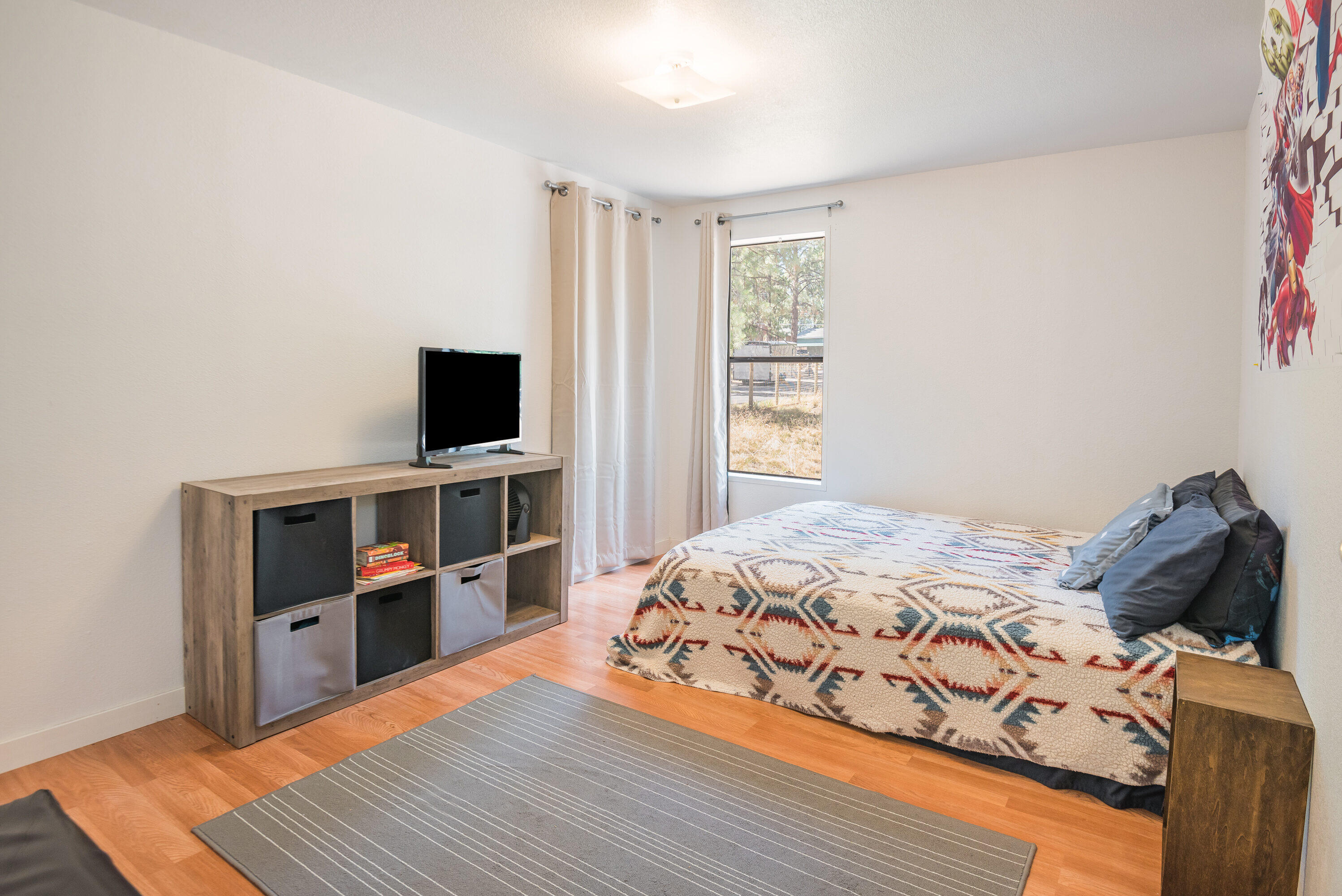 18749 Choctaw Road Bend, OR 97702 - Photo 12 of 22 a bedroom with a bed and a flat screen tv