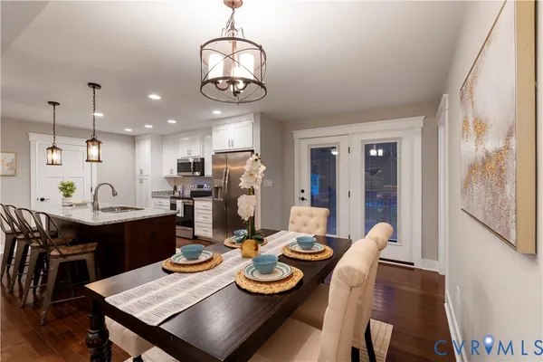 a view of a dining room with furniture a chandelier and wooden floor