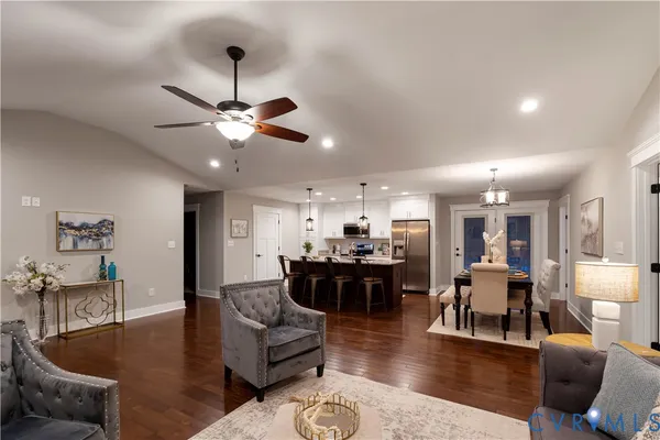 a living room with furniture kitchen view and a chandelier