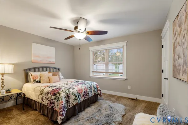 a bedroom with a bed chandelier and a window