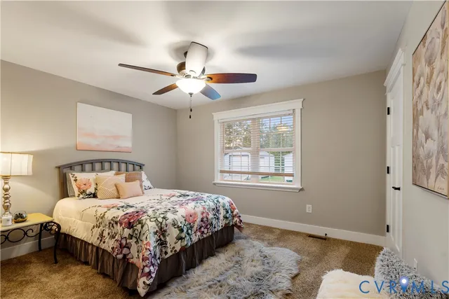 a bedroom with a bed chandelier and a window
