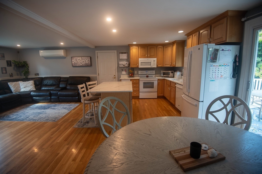 18 Birchwood Road Rutland, MA 01543 - Photo 21 of 42 a kitchen with stainless steel appliances granite countertop a refrigerator a stove a sink a dining table and chairs with wooden floor