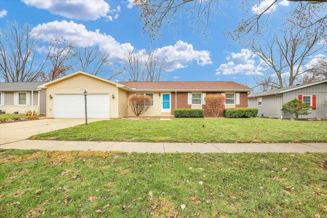 a view of house with a big yard and large trees