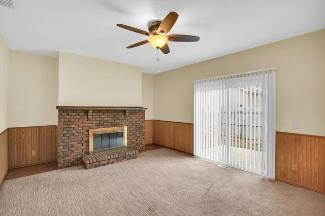 a view of an empty room with a fireplace and a window