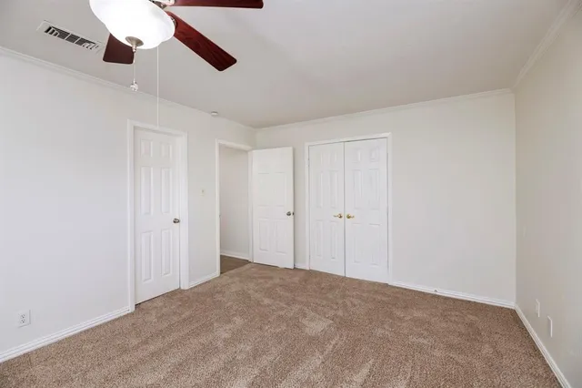 a view of an empty room and a ceiling fan