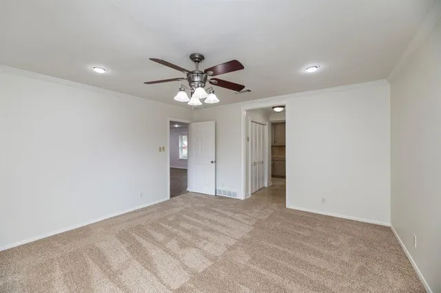 a view of a big room with a chandelier fan and windows