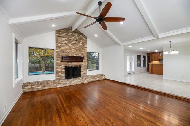 a view of a big room with wooden floor a fireplace and a window